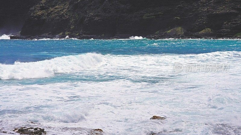 太平洋的蓝色海浪打败了瓦胡岛火山悬崖。蓝绿色的水的颜色。晴朗的一天。夏威夷群岛。DCI 4 k。缓慢的运动。